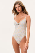 Woman wearing a floral one-piece swimsuit on a white background