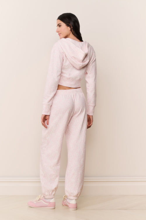 Woman wearing a pink tracksuit against a white background