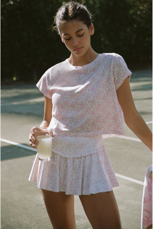 Woman in a white outfit standing on a tennis court