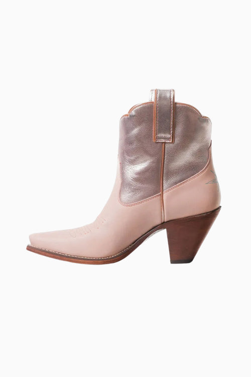 Pink cowboy boot with metallic silver heel on a white background