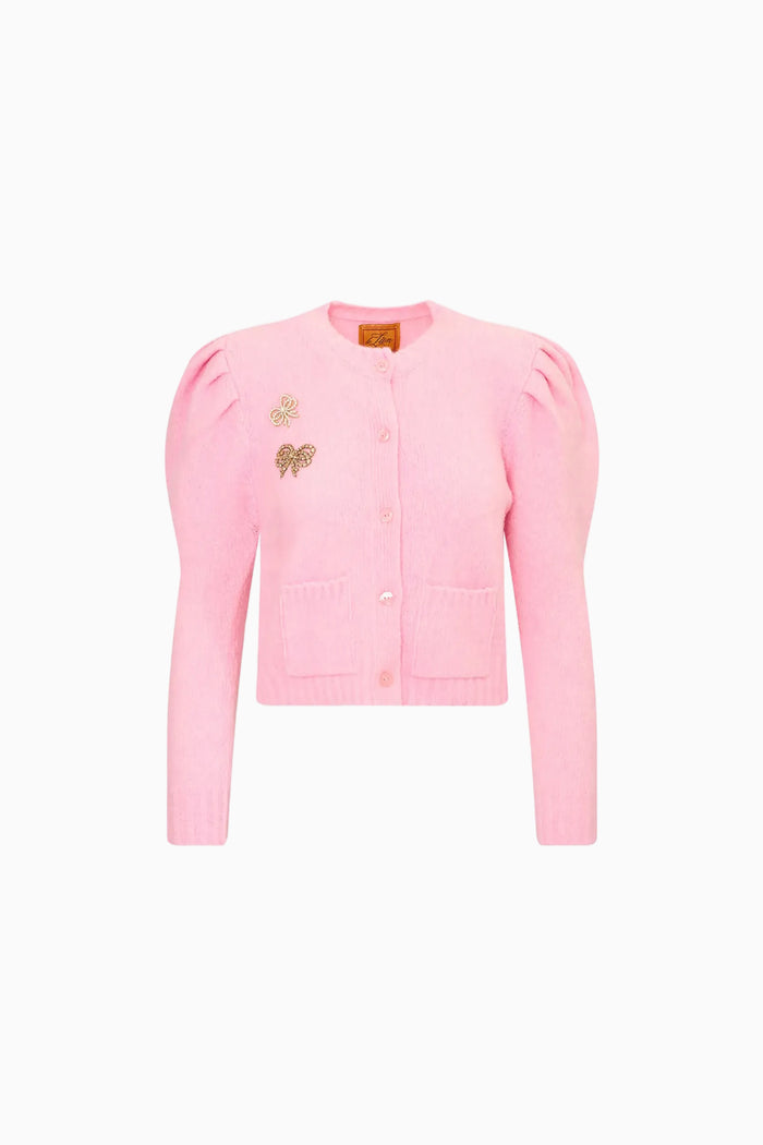 Pink cardigan with a 2 bow embellishments on a white background