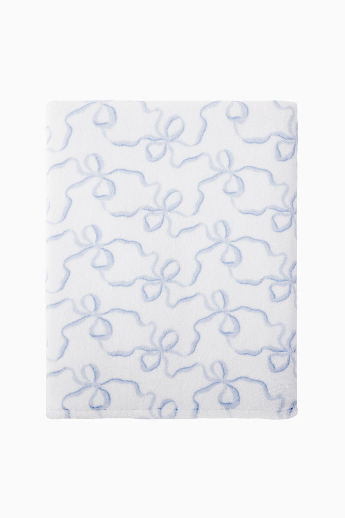 White towel with blue bow pattern on a white background