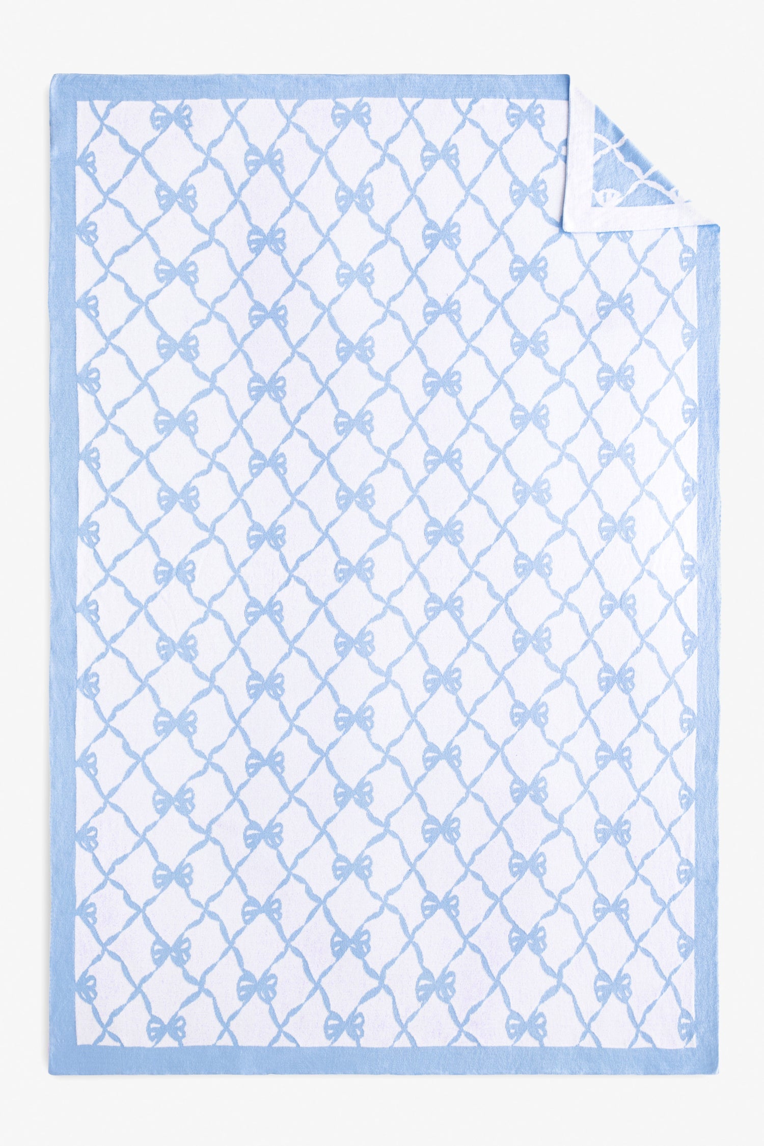 Reversible throw blanket with bow print.