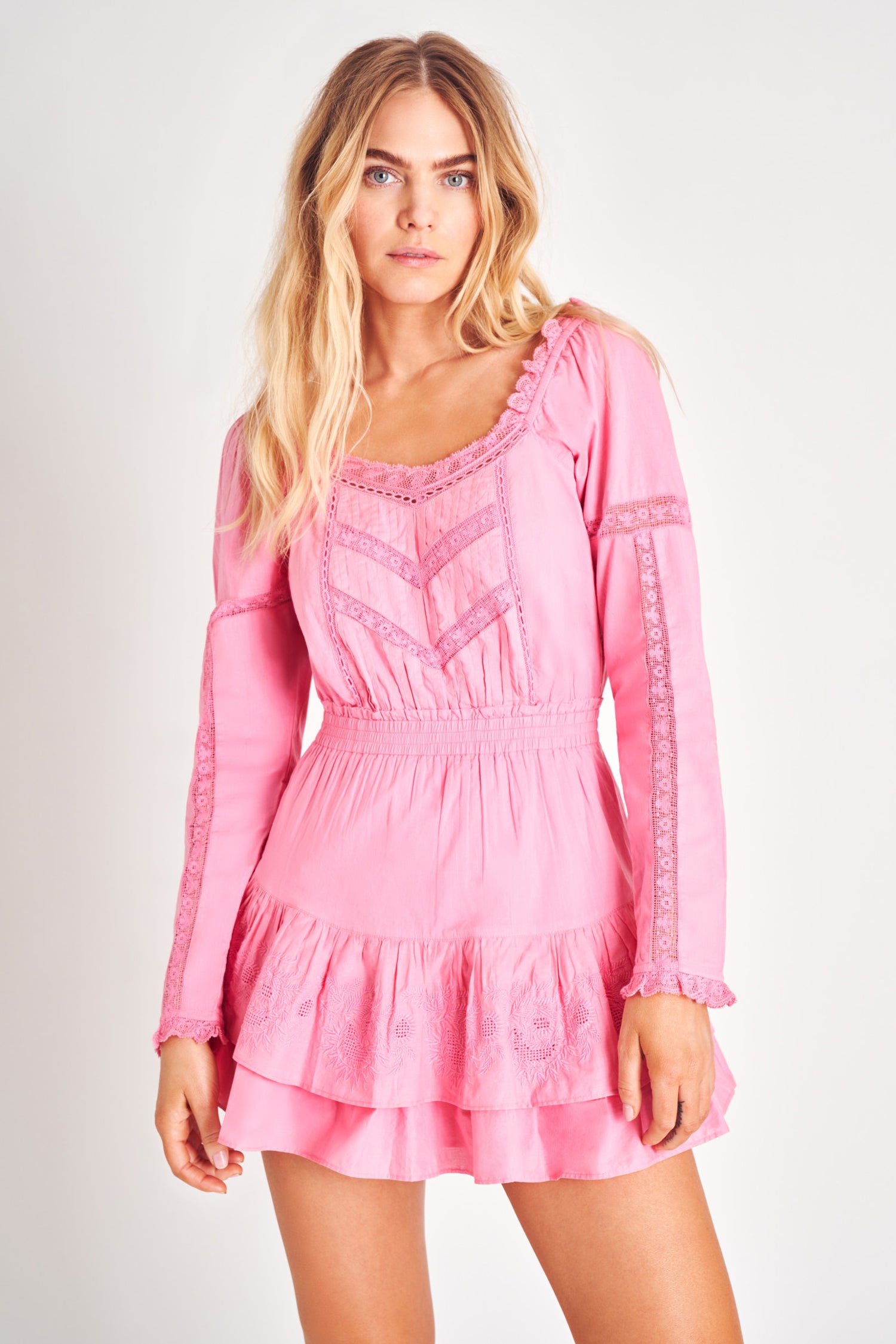 Pink long sleeve ruffle mini dress with lace detailing.