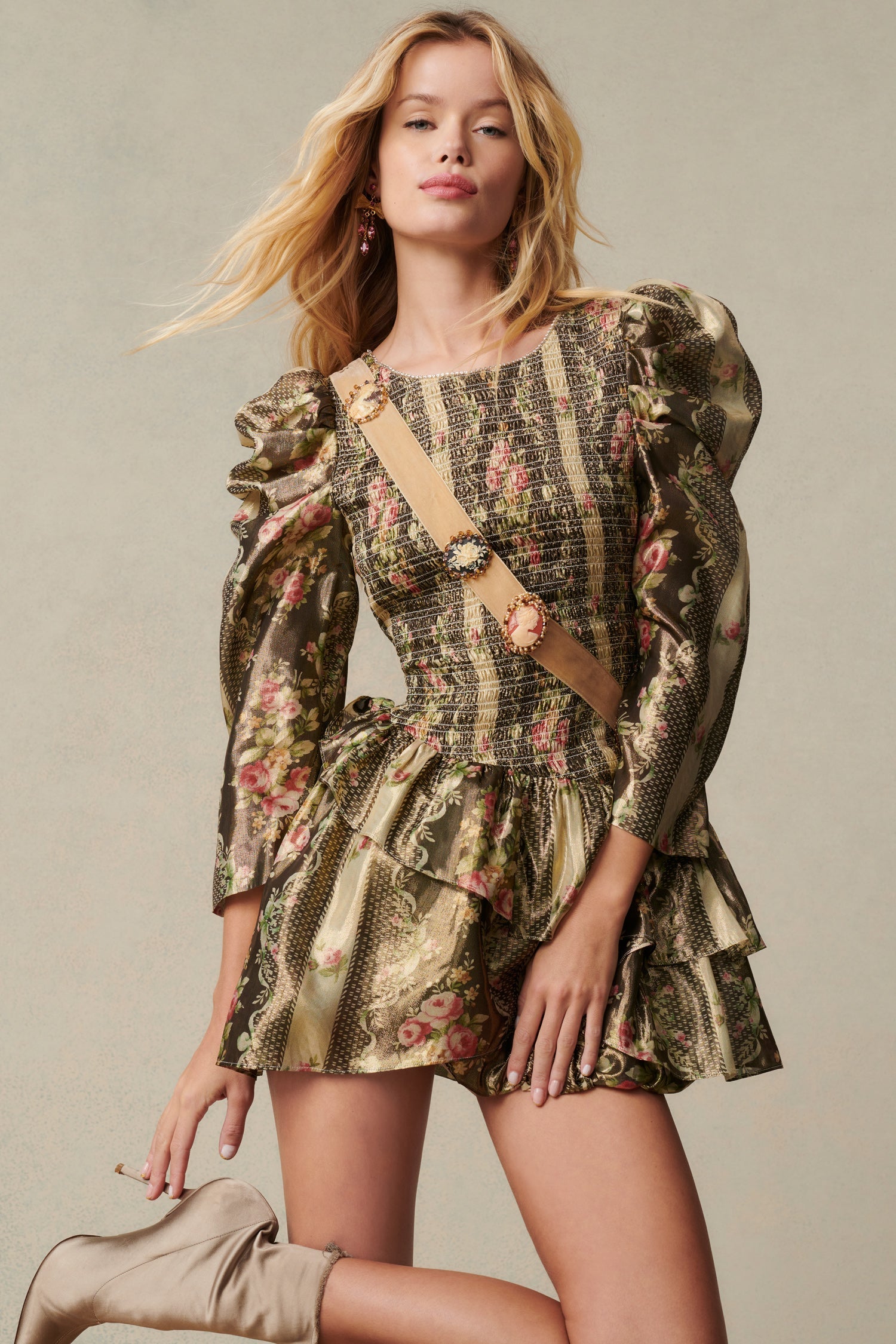 Green and floral mini dress with a printed lurex lame fabric the dress features a smocked bodice, elegant mutton sleeves with shirring at the shoulders that taper into a clean opening, and an asymmetrically tiered skirt. 