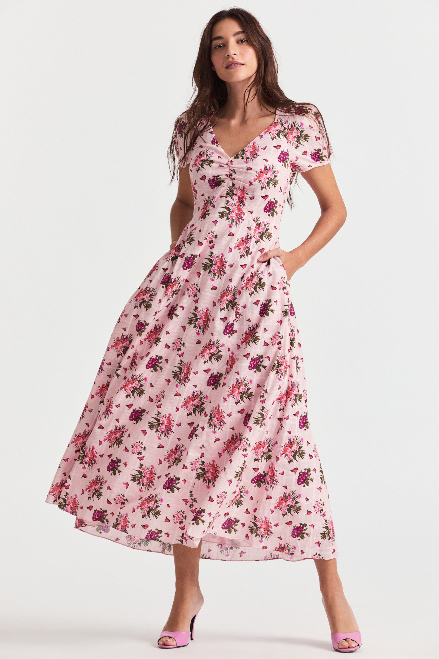  Pink floral maxi dress with shirred detailing sits around a square v-neck above a ruched center front. The dress falls to an easy swing skirt.