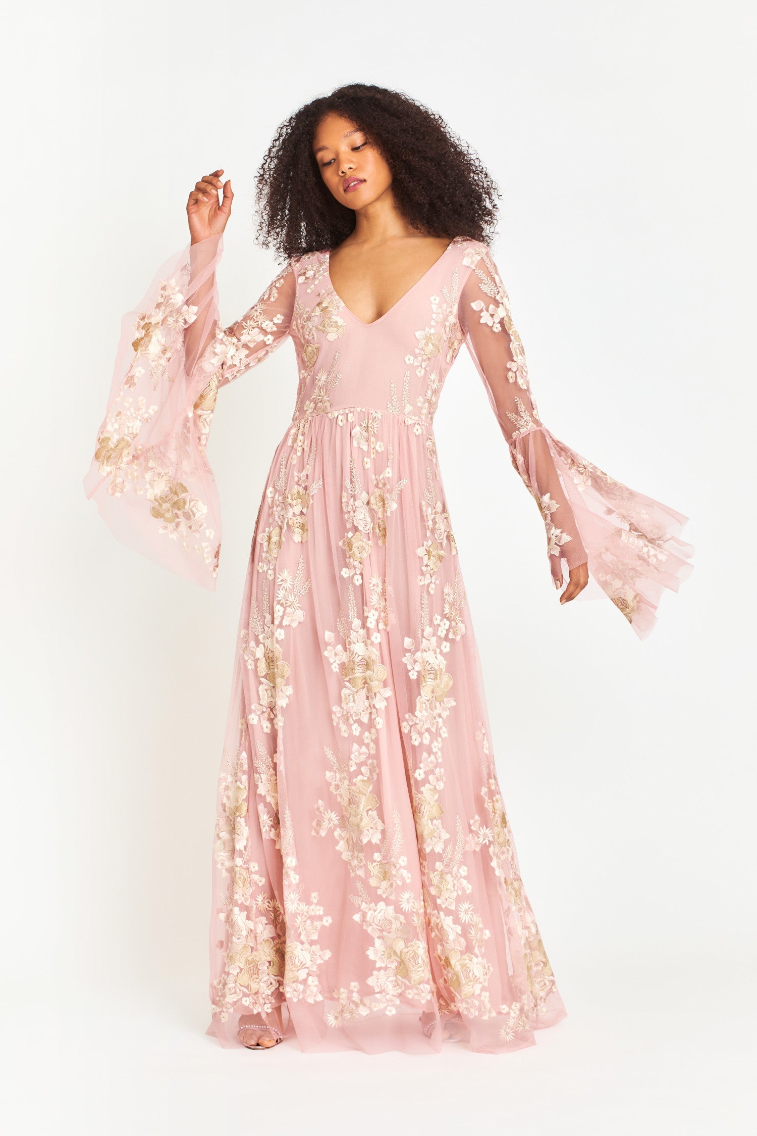 Pink maxi dress features a plunging neckline and high to low bell sleeves with floral applique