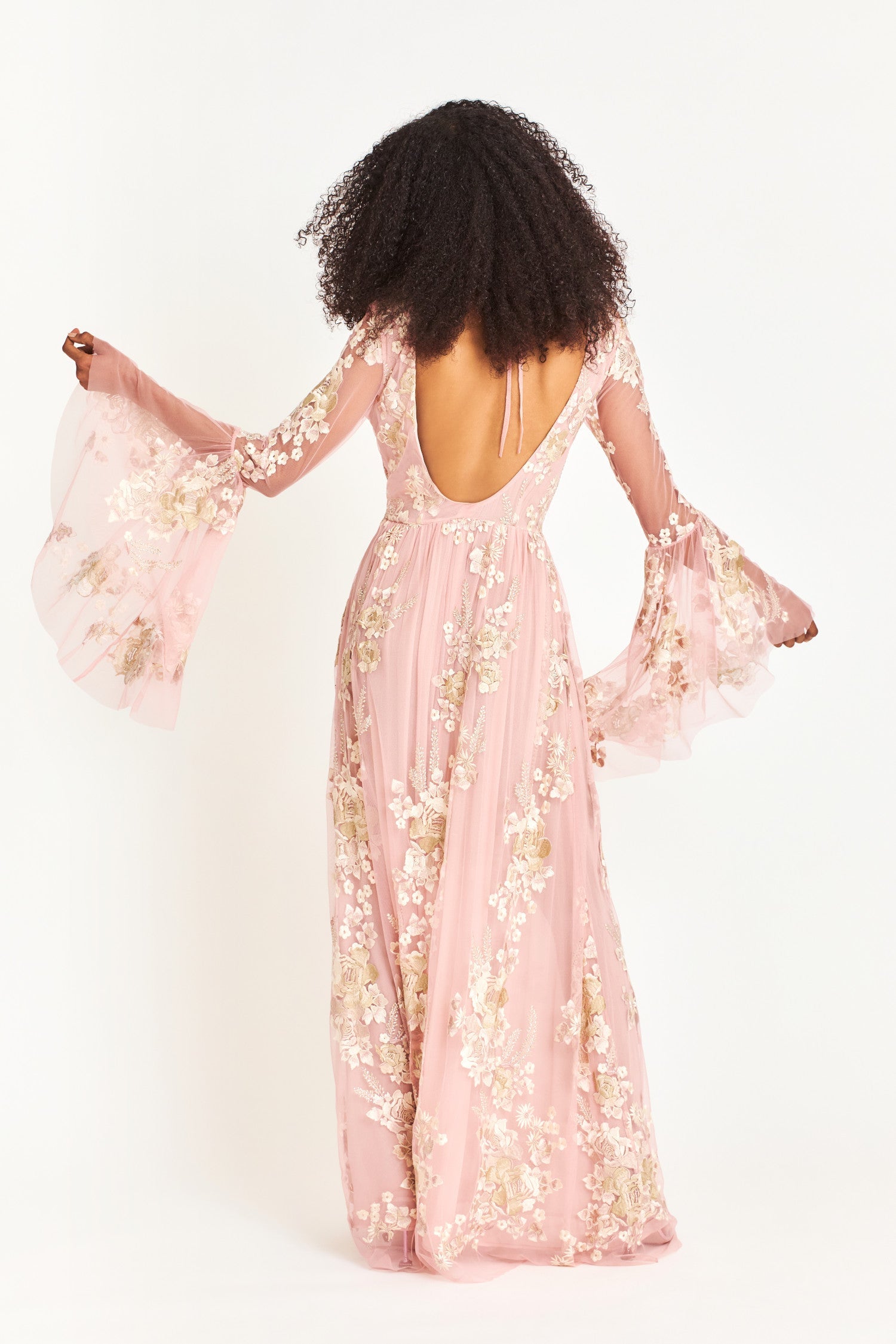 Pink maxi dress features a plunging neckline and high to low bell sleeves with floral applique
