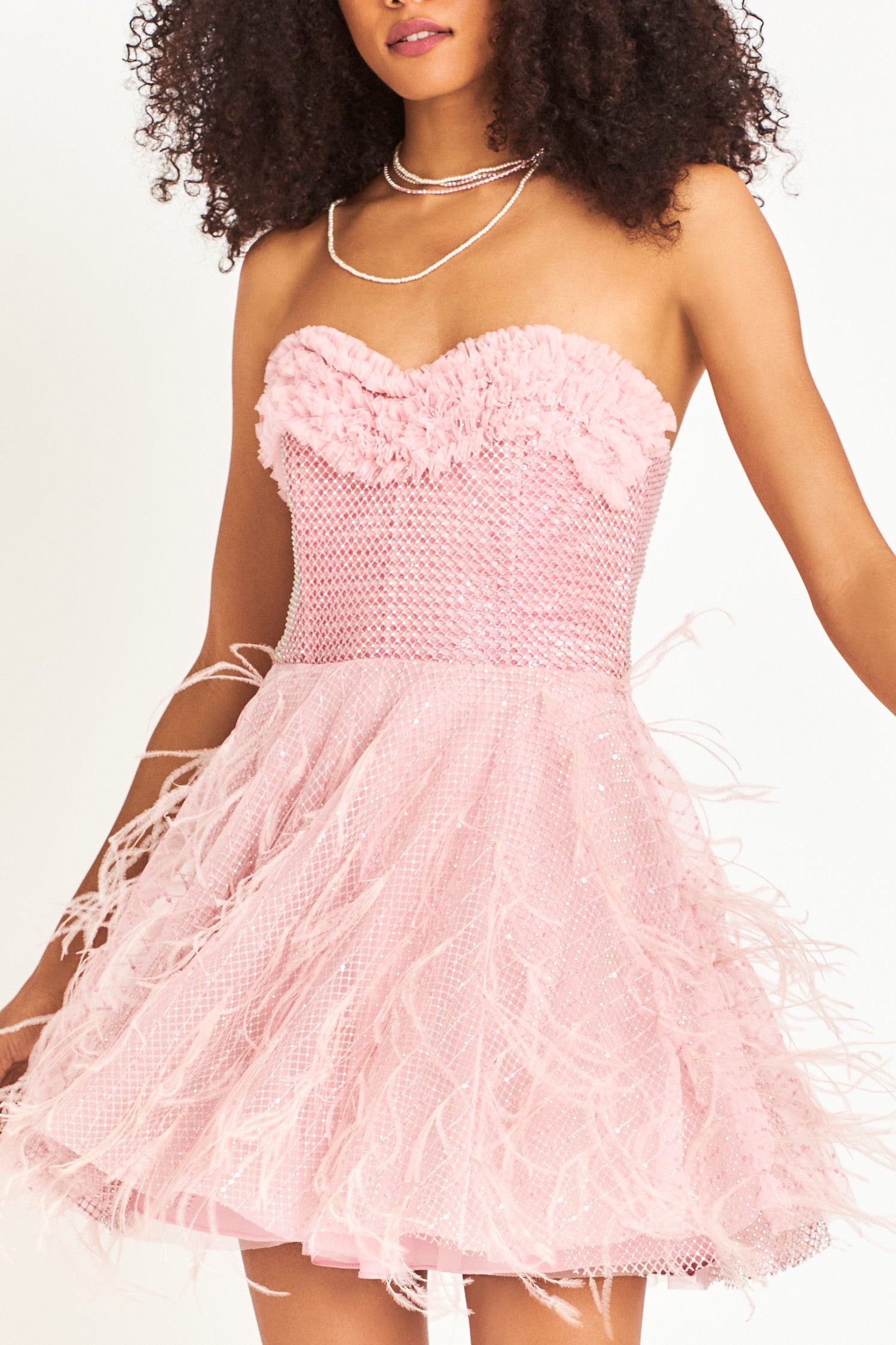 Pink mini dress with structured bodice, boning, and a multi-layered skirt with feathers