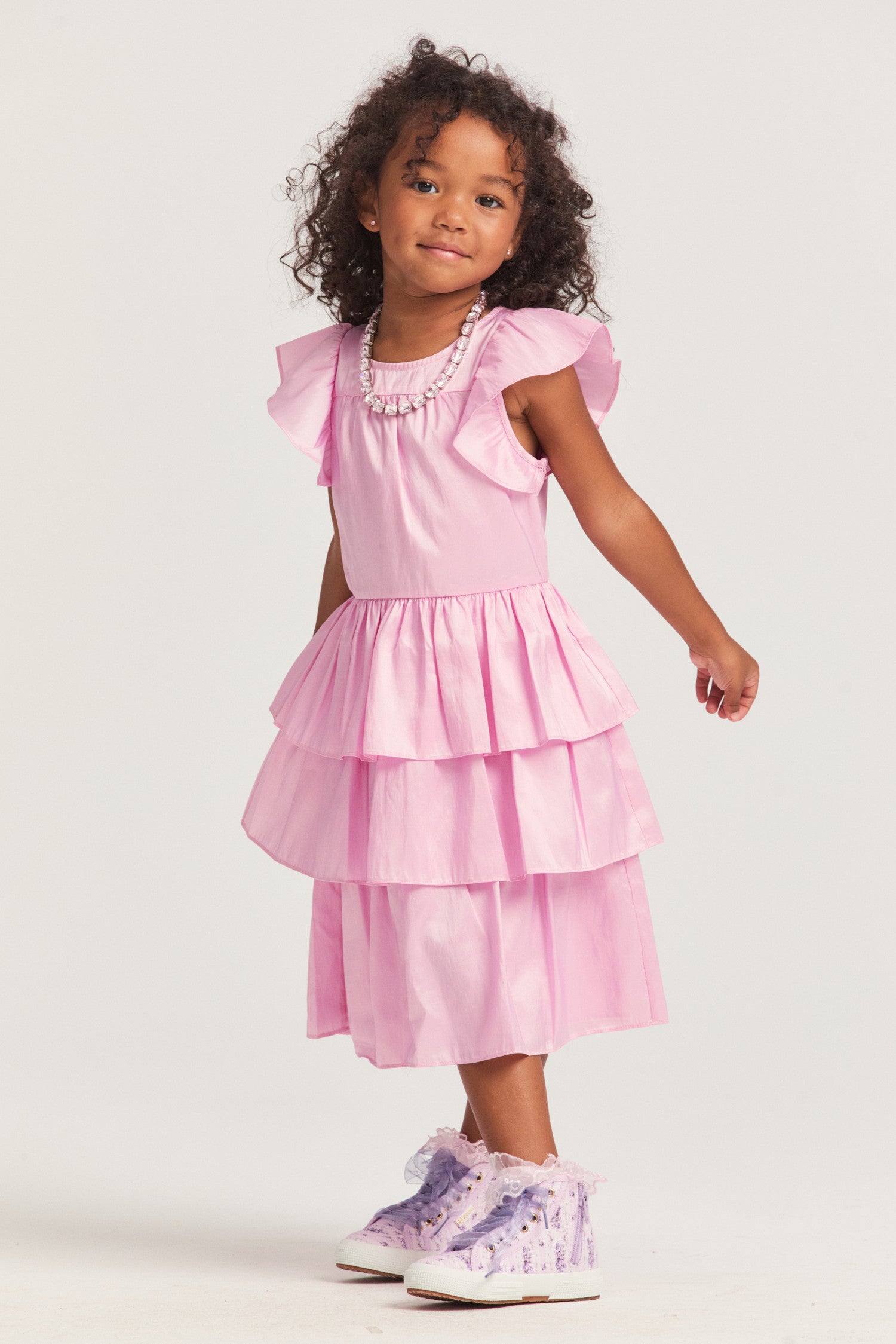 Girls pink dress with nylon fabric, and flutter sleeves frame the roomy bodice. An encased elastic waist lets out into a three-tiered ruffle skirt. 