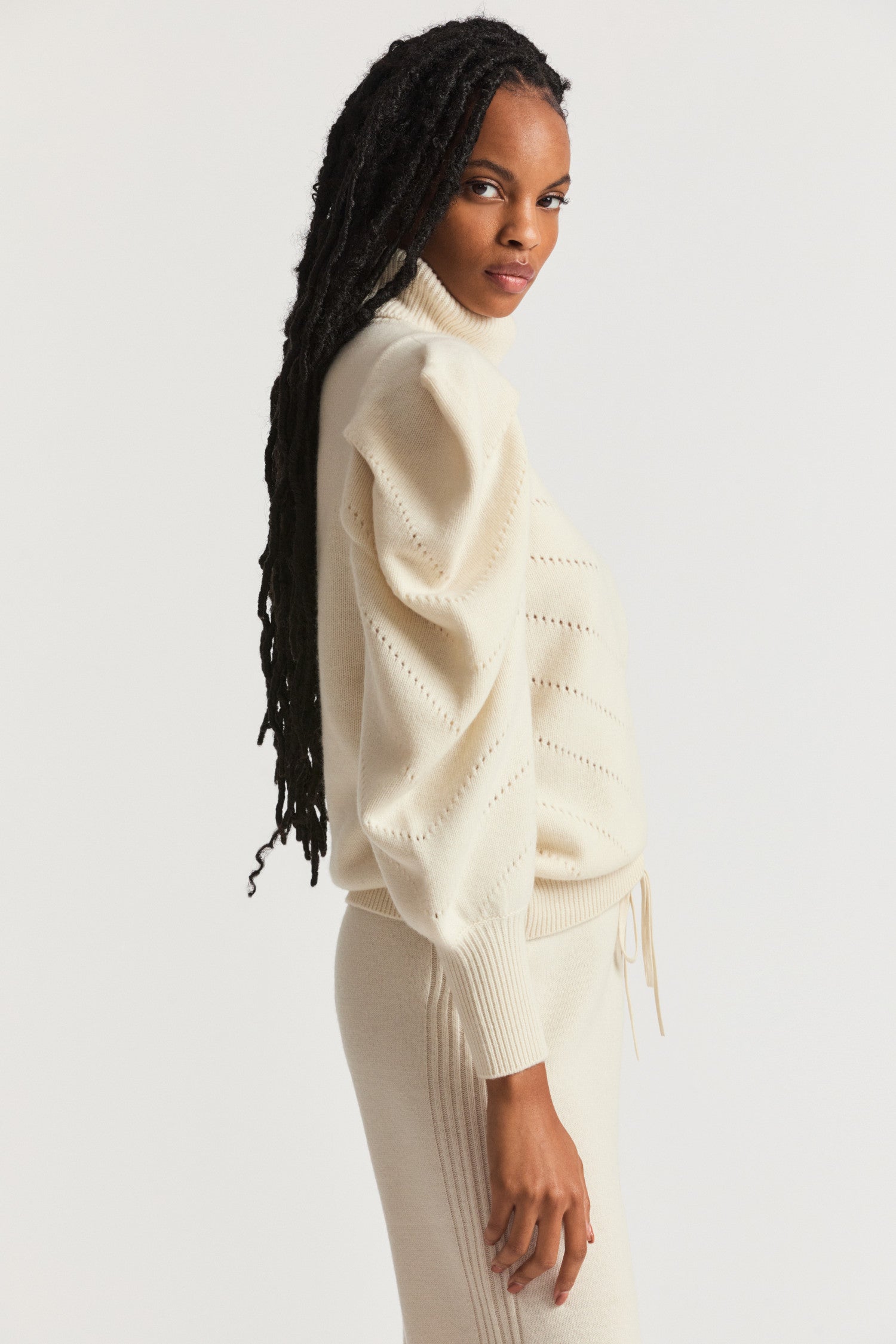 Cream sweater turtleneck in a wool cashmere fabric.  With angel chevron pointelle detailing on the front and pleated Victorian-inspired sleeves with a high cuff.