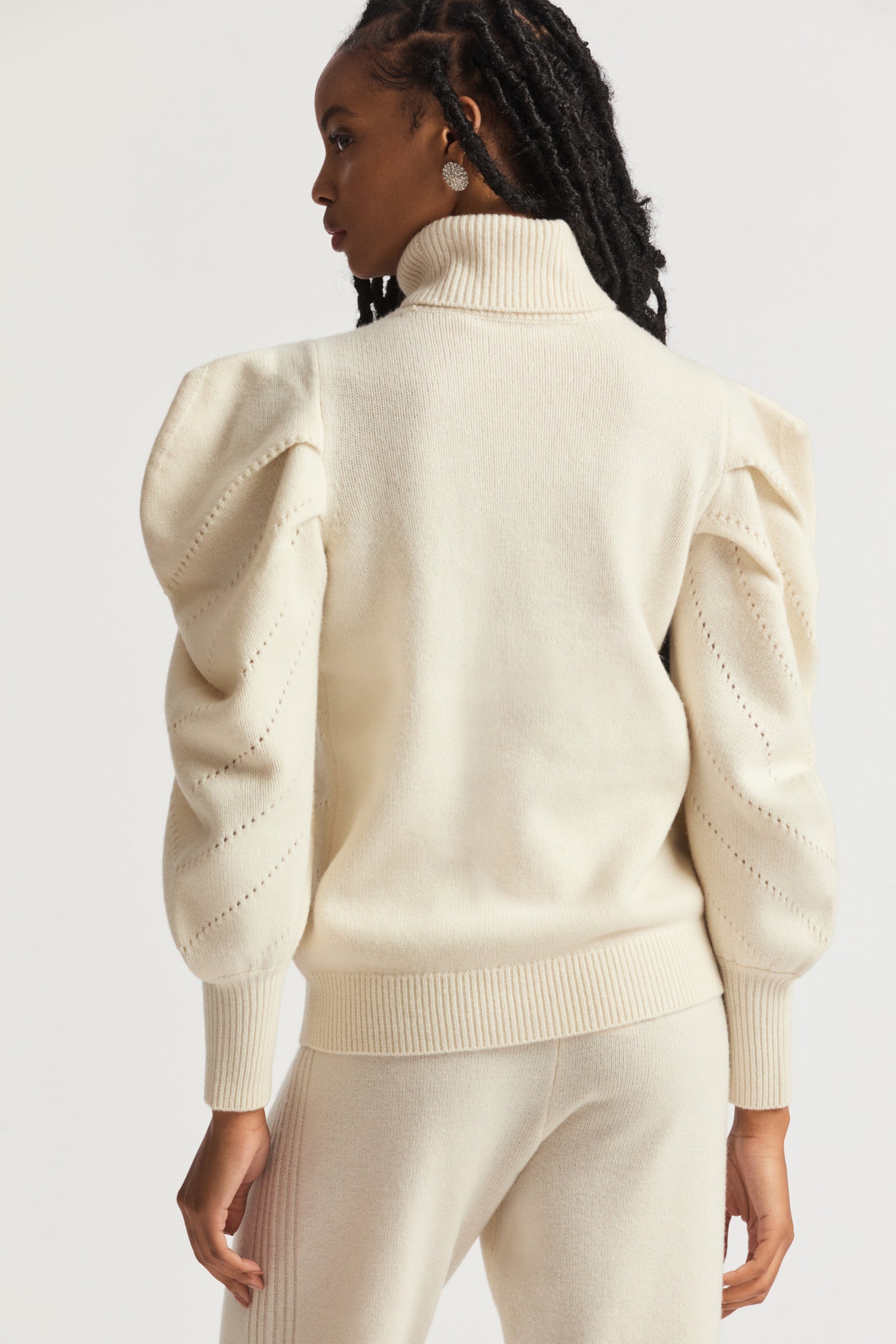 Cream sweater turtleneck in a wool cashmere fabric.  With angel chevron pointelle detailing on the front and pleated Victorian-inspired sleeves with a high cuff.