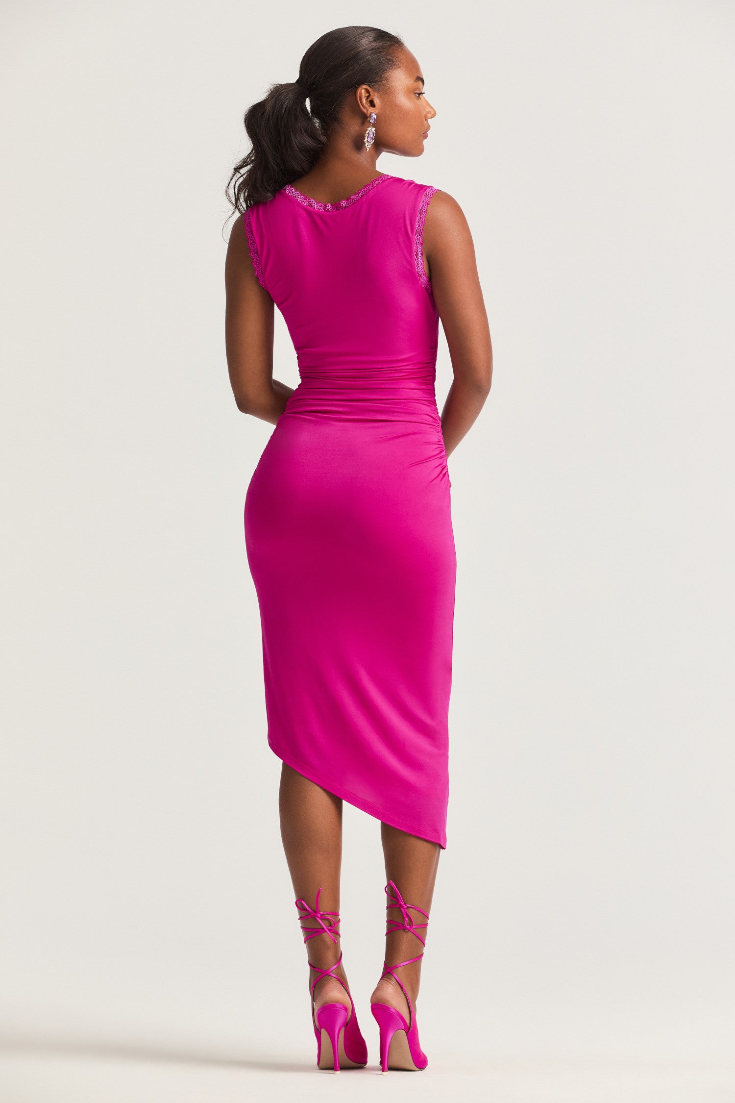 Bright pink midi dress with slinky ruched jersey fabric with a slim fit, a round scoop neckline and falls to an asymmetrical hem finish. 