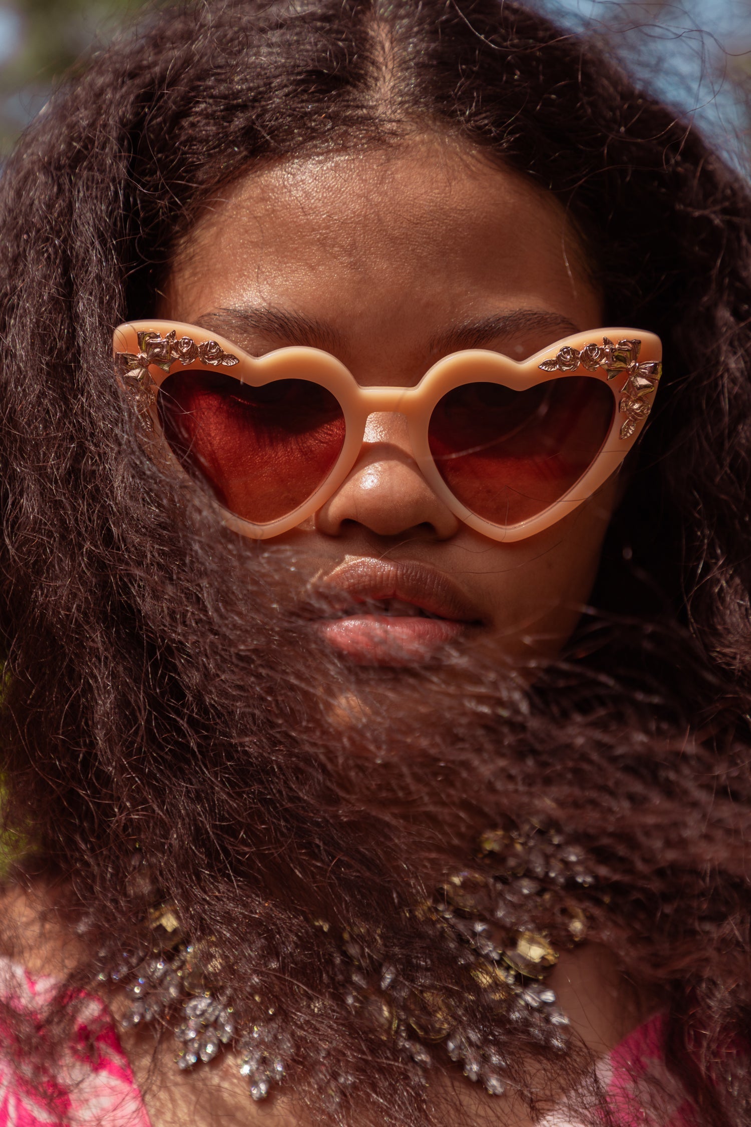 Womens heart shaped golden peach sunglasses with gem detail.