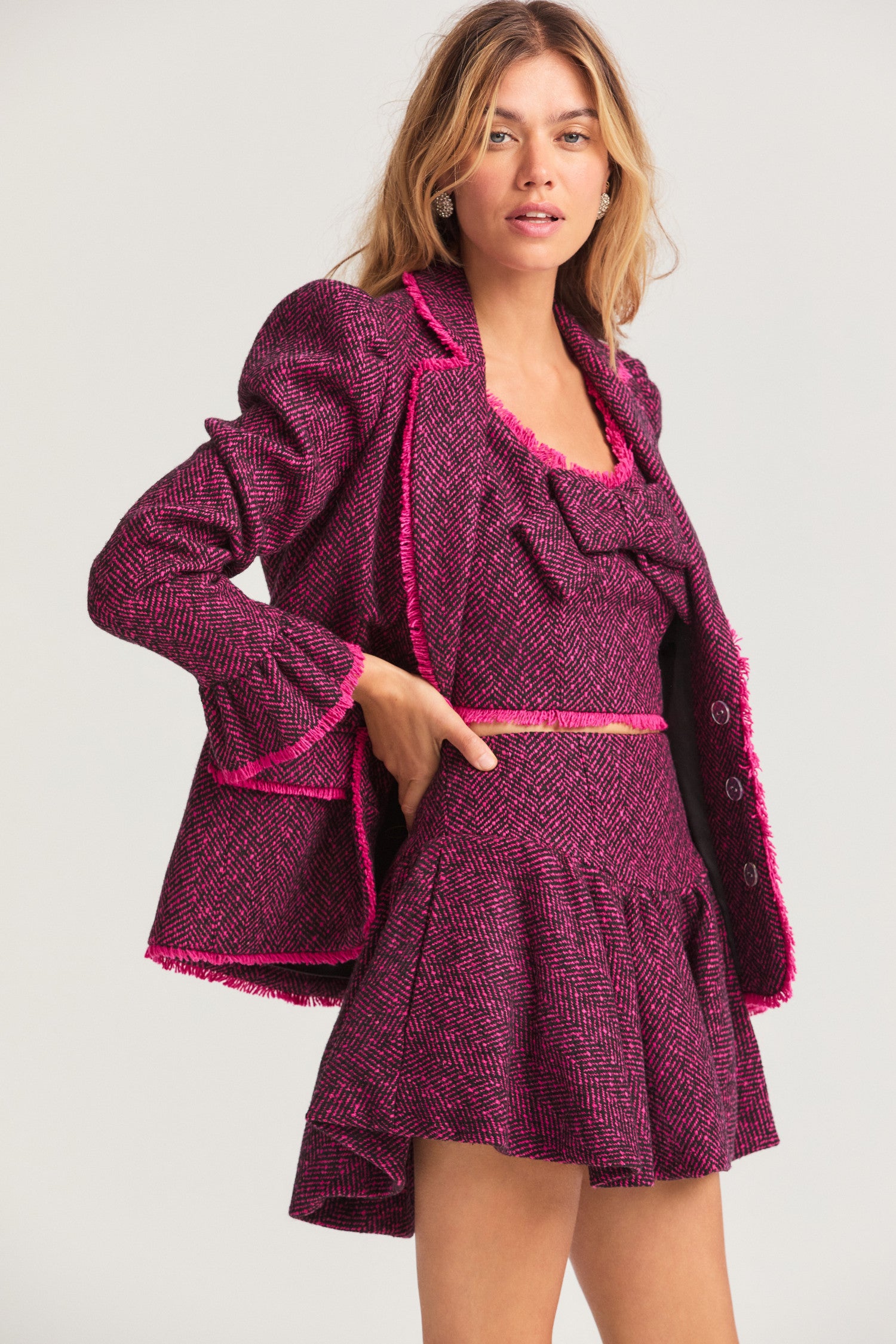 Fuchsia blazer with fraying details for a vintage look, slightly puffed shoulders, a ruffled cuff, flat pockets, and three self-covered buttons.