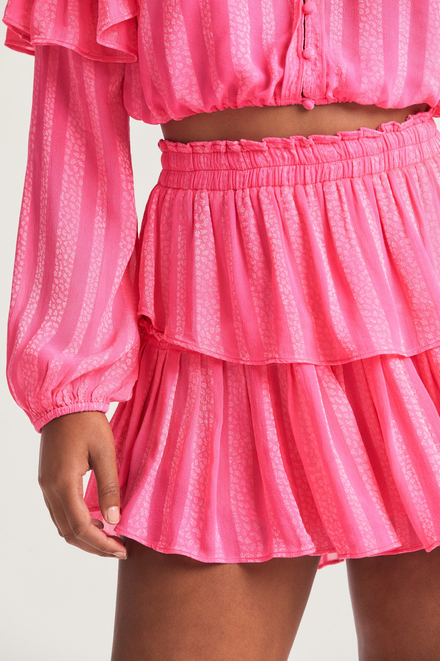 Pink mini skirt in viscose fabric with bow print. The two-tiered short skirt, with an elasticated waistband and shirred flounces.