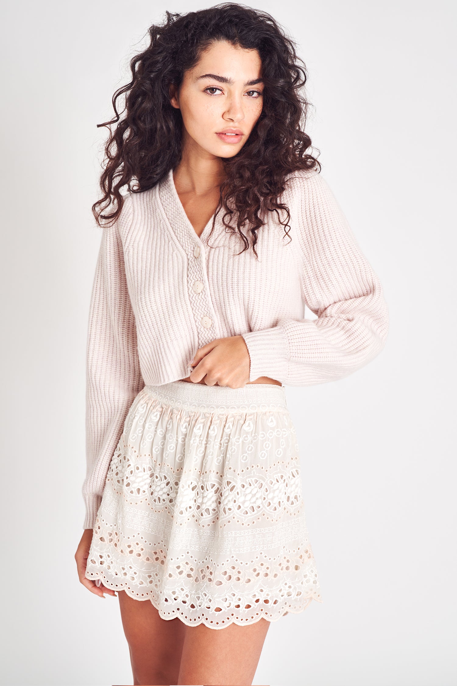 Cream mini skirt with eyelet and embroidery detailing, featuring an A-line hem.