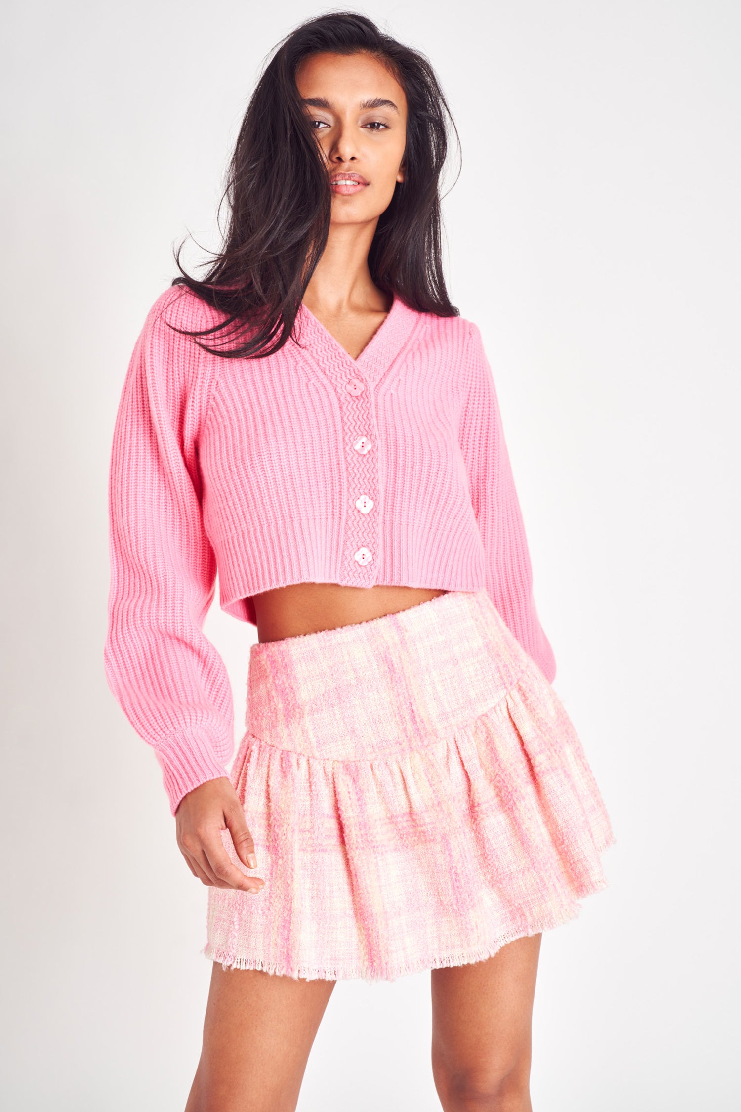 Light pink tweed mini skirt with a flattering waistline and fringe hem.