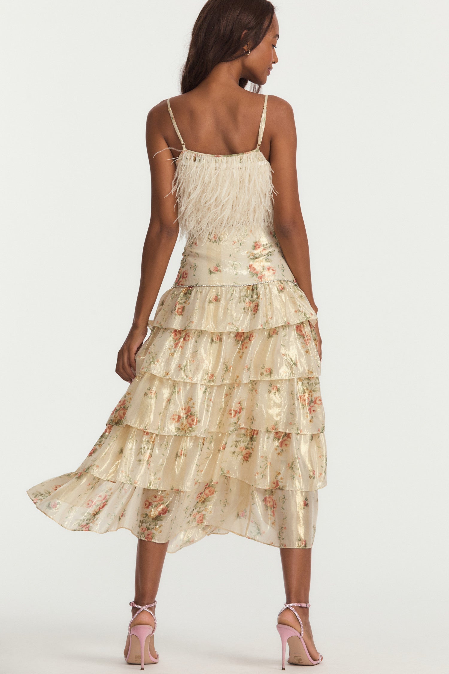 Off-white midi skirt, with floral print that paints a lurex lame fabric featuring a rhinestone trim at the flounce seam and yoke, a slit on the left, and a gold exposed metal zipper. 