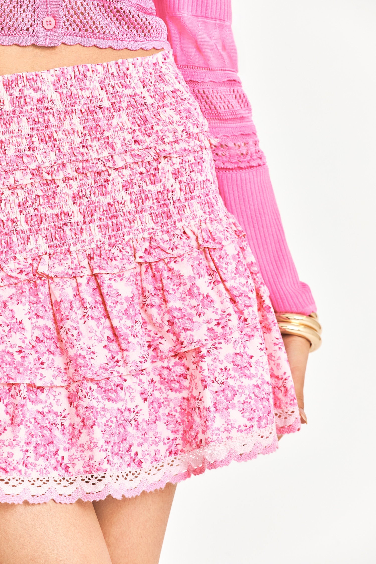 Pink skirt featuring smocked waist , ruffle tiers, and crochet lace
