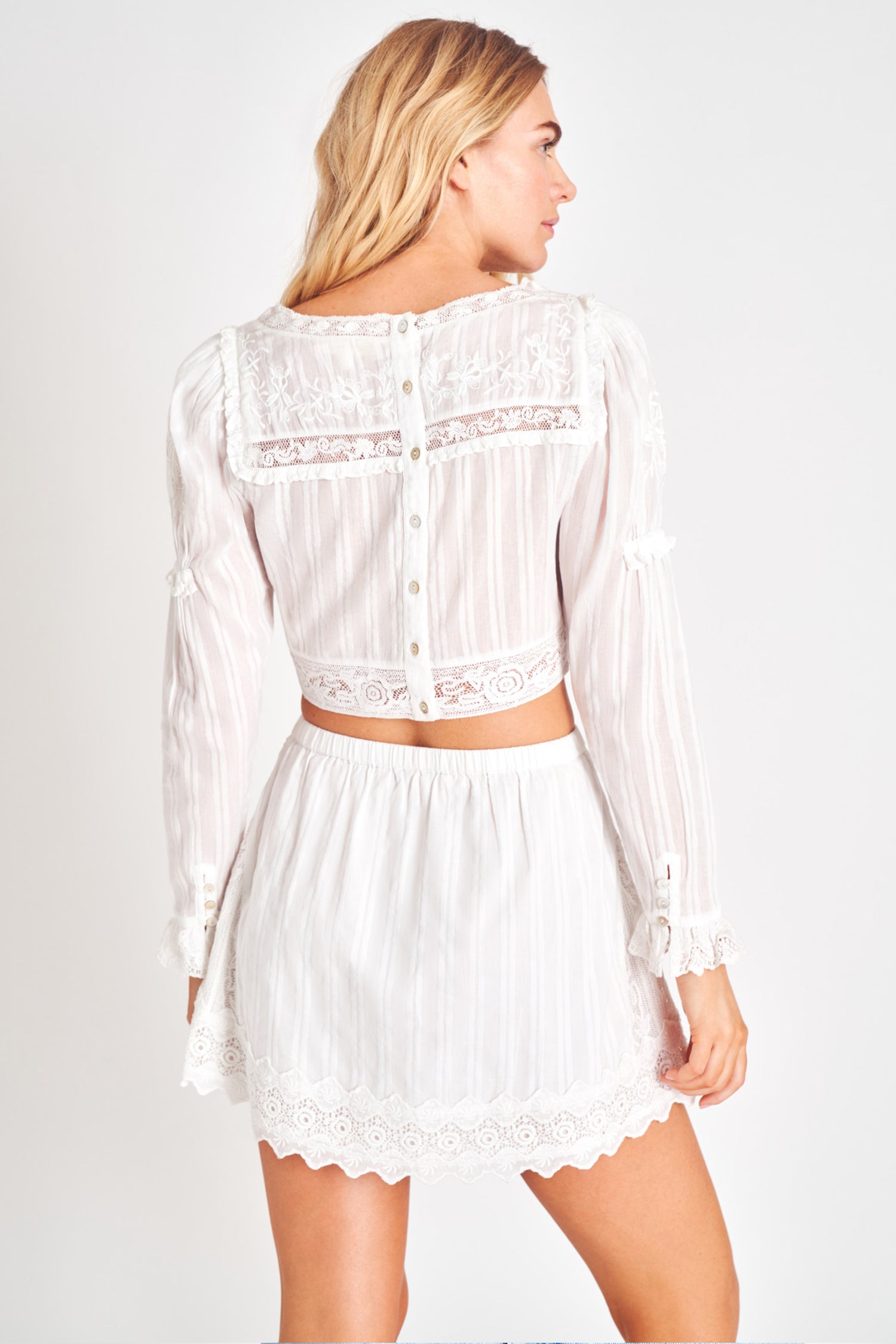 White embroidered long sleeve crop top.