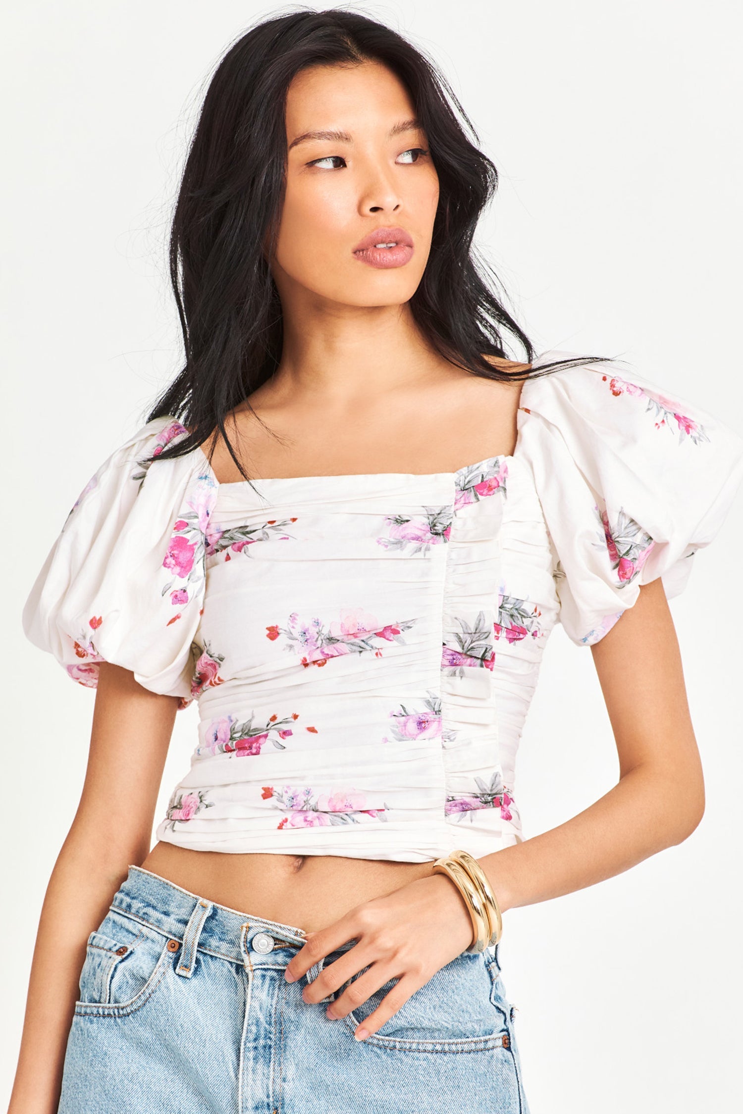 White top with floral design features a smocked bodice with eyelet printed cotton and puff sleeves
